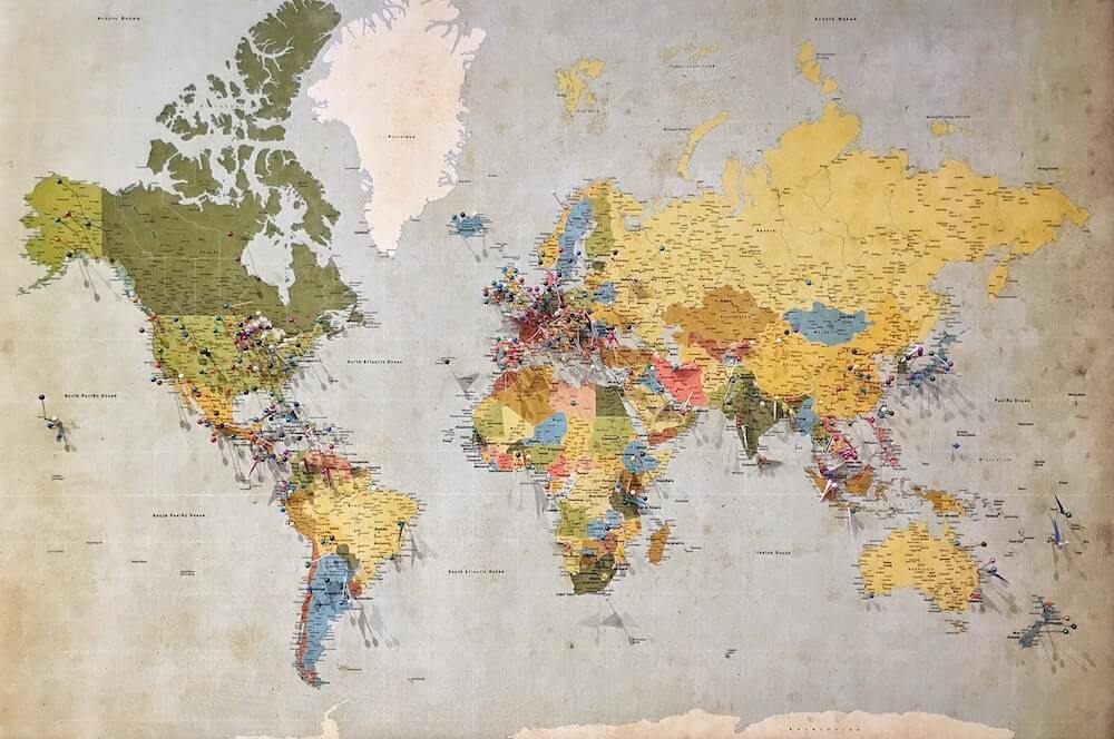 A world map with pins in it.