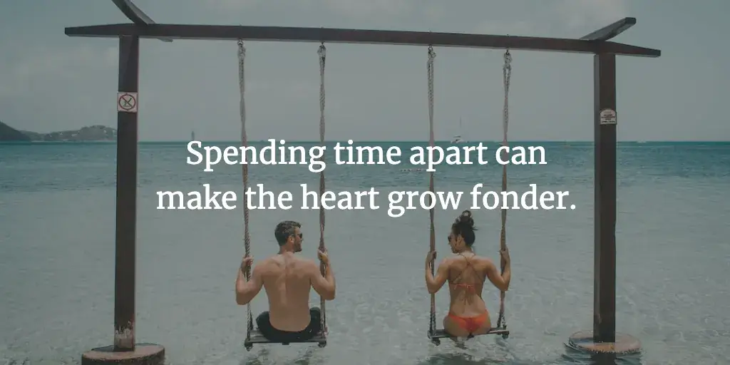 A travel couple sits on a swing overlooking the ocean. The text reads, 'Spending time apart can make the heart grow fonder.'