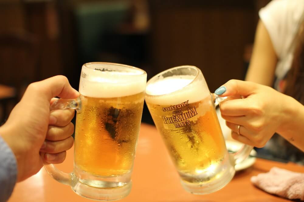 Two people cheers with beer steins.