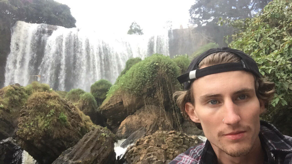 Harrison Dale (solo traveller and founder of Nomadic Yak) next to a waterfall in Dalat, Vietnam.