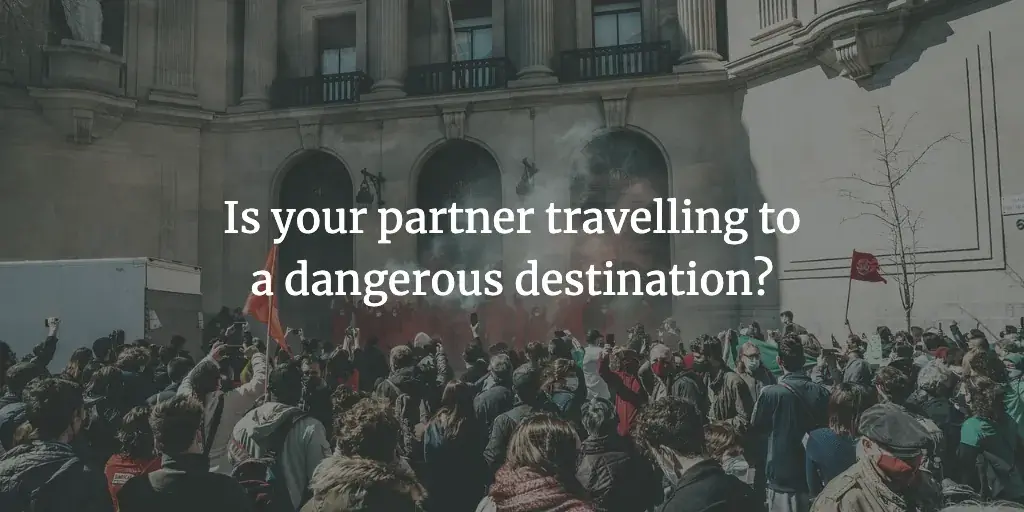 A riot of people waving red flags and releasing red flares. The text reads, 'Is your partner travelling to a dangerous destination?'
