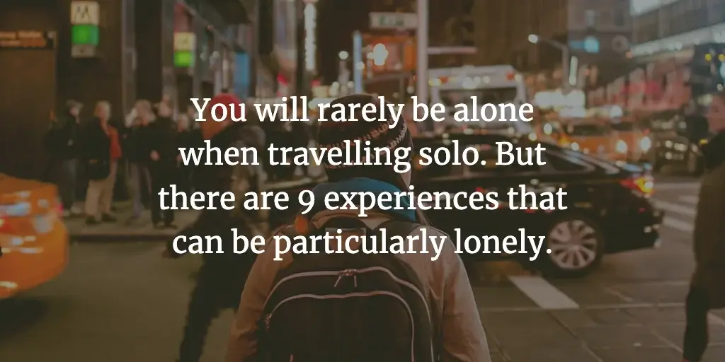 A backpacker stands in a busy street. The text reads, 'You will rarely be alone when travelling solo. But there are 9 experiences that can be particularly lonely.'