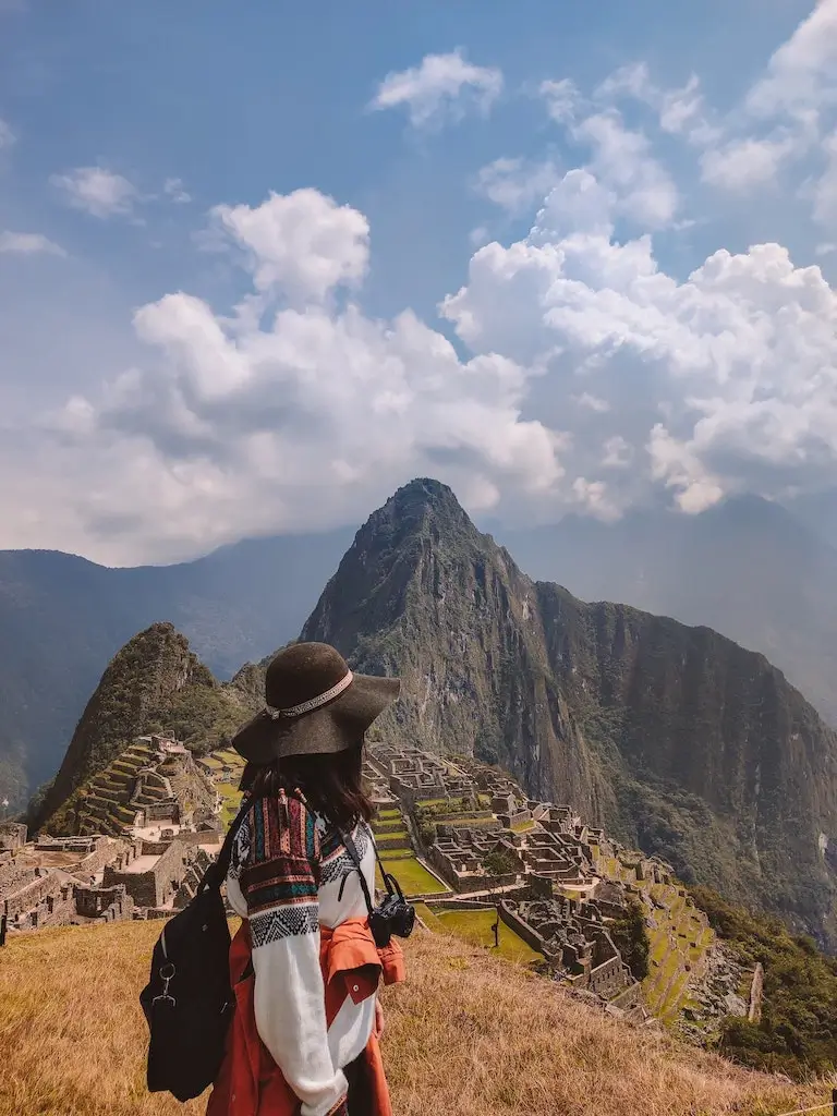 Solo female traveller standing overlooking Machu Picchu, Peru.
