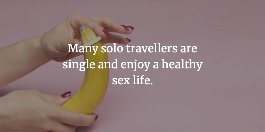 A woman's hands slide a condom onto a banana. The text reads, 'Many solo travellers are single and enjoy a healthy sex life.'
