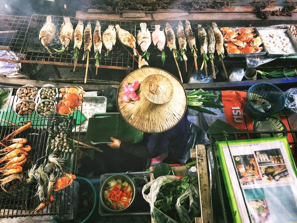 A woman prepares street food in Asia.
