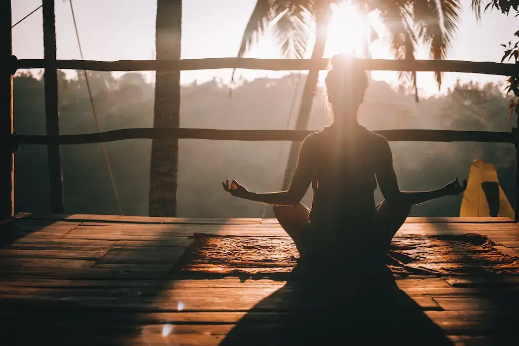 A woman practicing yoga and meditating in Bali