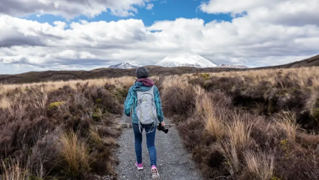 A female solo traveller hiking Tongariro National Park, New Zealand.