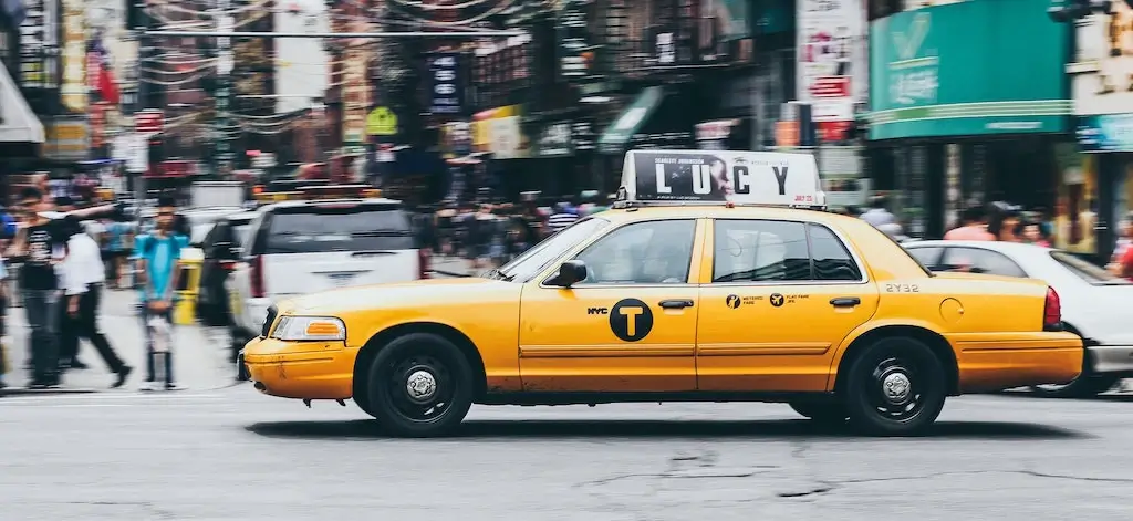 Yellow taxi driving through New York City, USA.