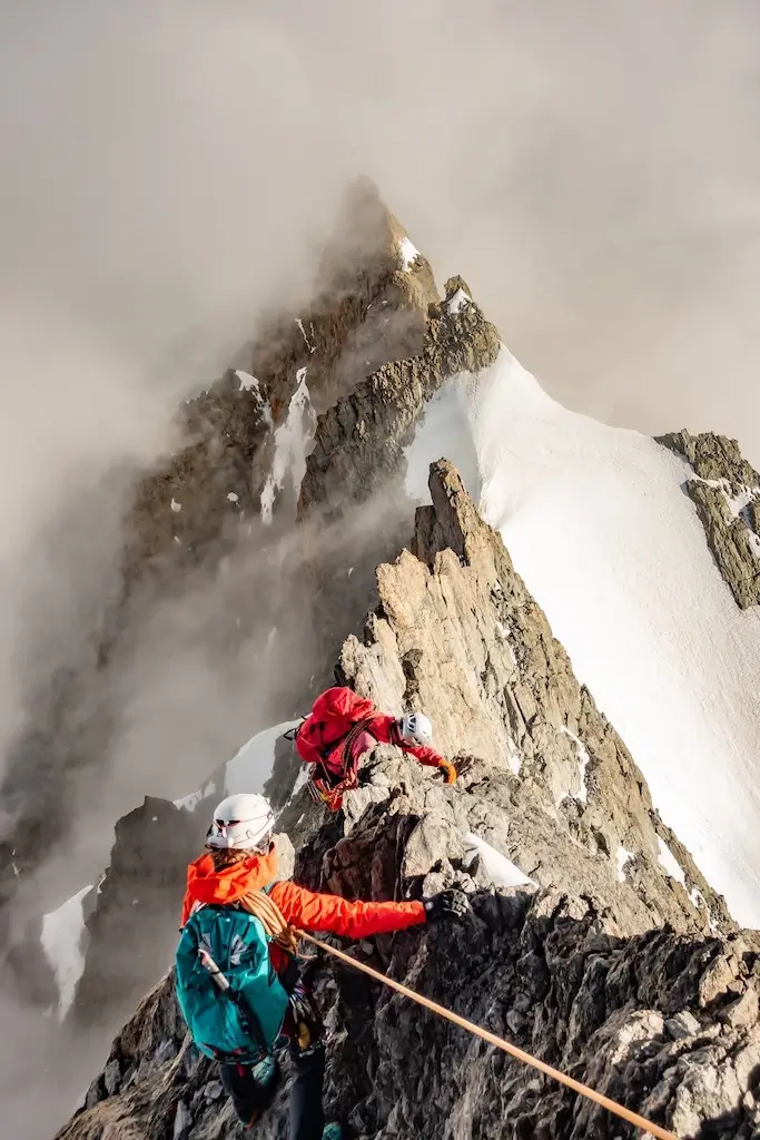 Tourists mountain climbing a snowy peak in Switzerland.
