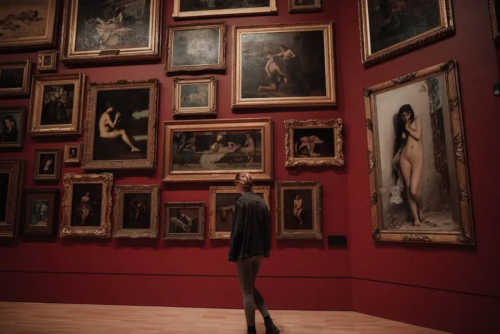 Woman admiring paintings in an art museum.