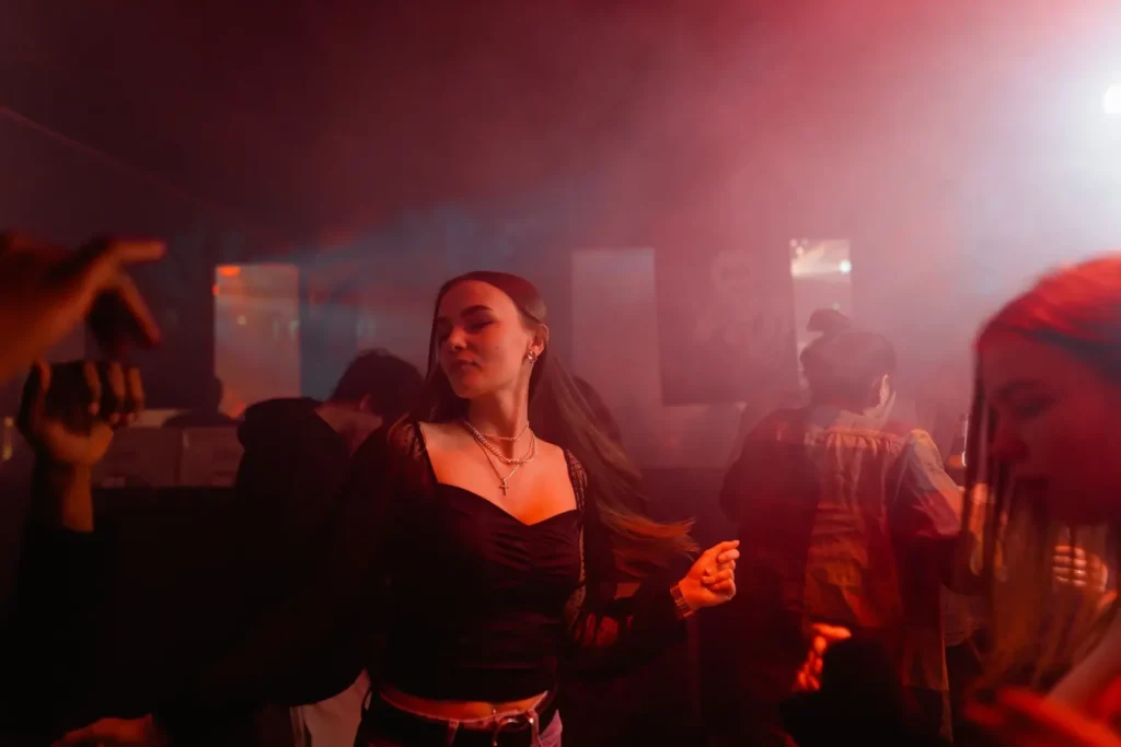 Female backpacker dancing and partying in a club.