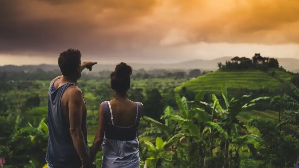 Couple travelling together through rice paddies in Bali, Indonesia.