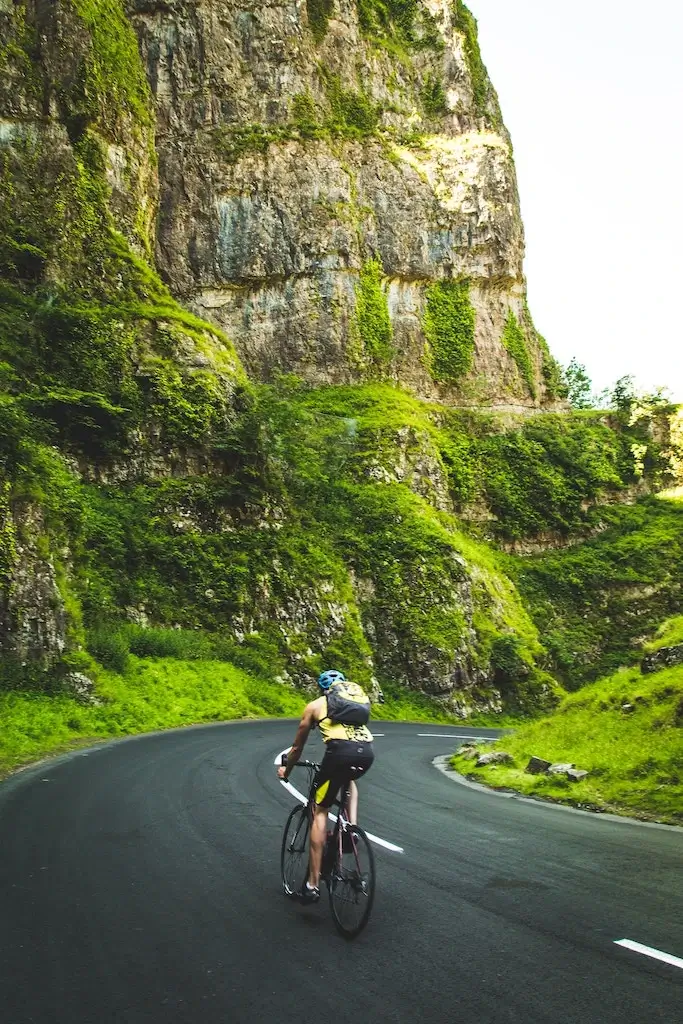 Male cyclist riding through Cheddar Gorge, UK.