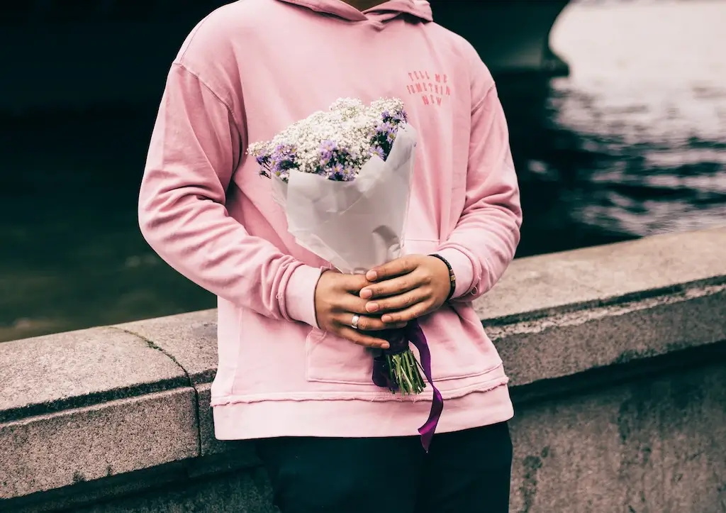 Man holding flowers as a gift.