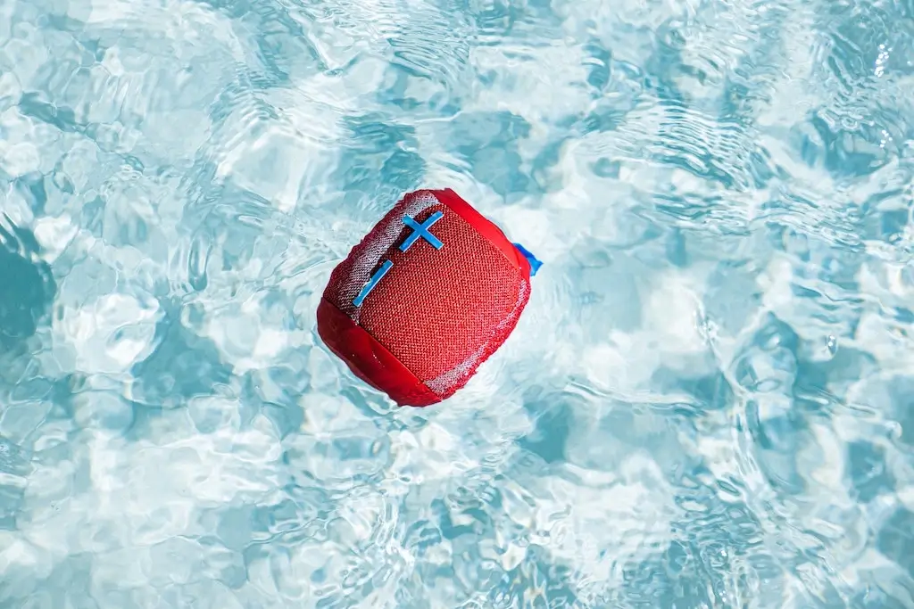 Mini music speaker floating in a pool.