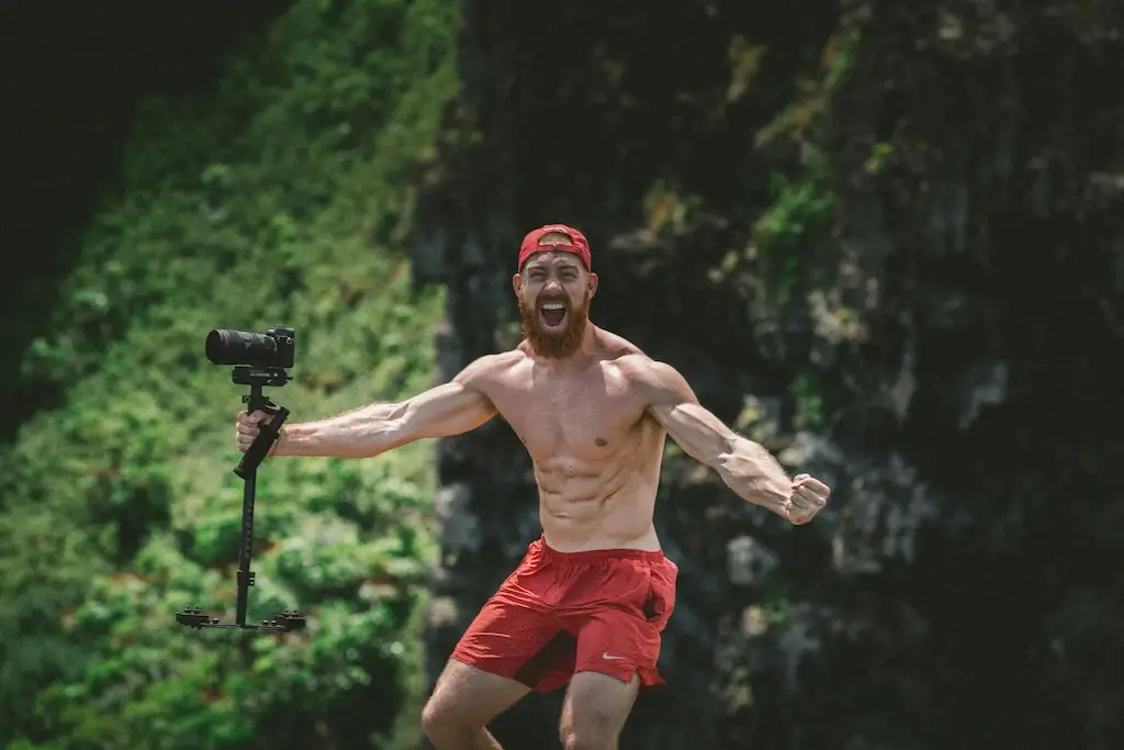 Muscular male solo traveller flexing with camera.