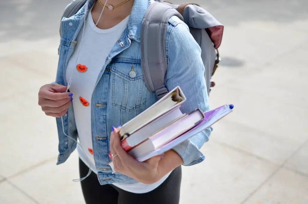 Student walking to class with textbooks.