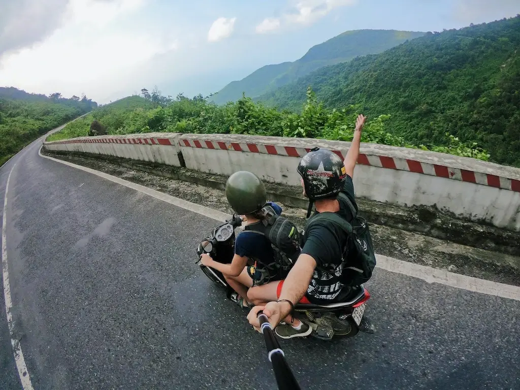Two tourists riding a motorcycle together through Vietnam.