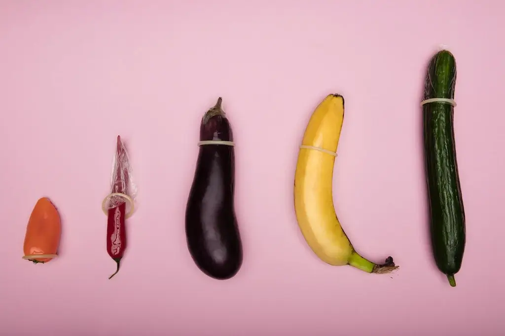 Different size vegetables wearing condoms.