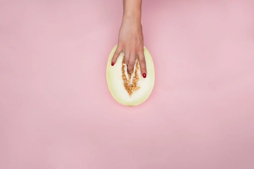 Woman's hand fingering a melon.