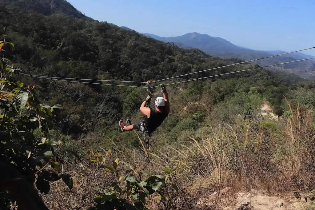Male tourist riding a zipline in Mexico.