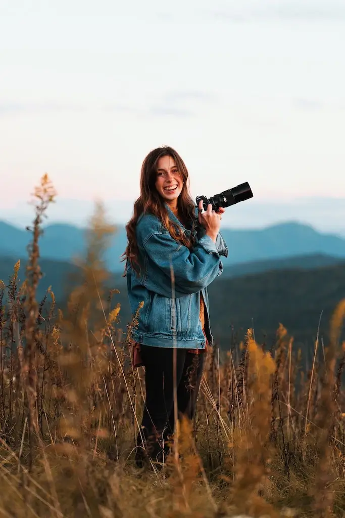Solo female photographer in the hills with a camera.