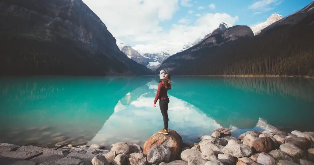 Solo female traveller posing in front of Lake Louise in Canada. 