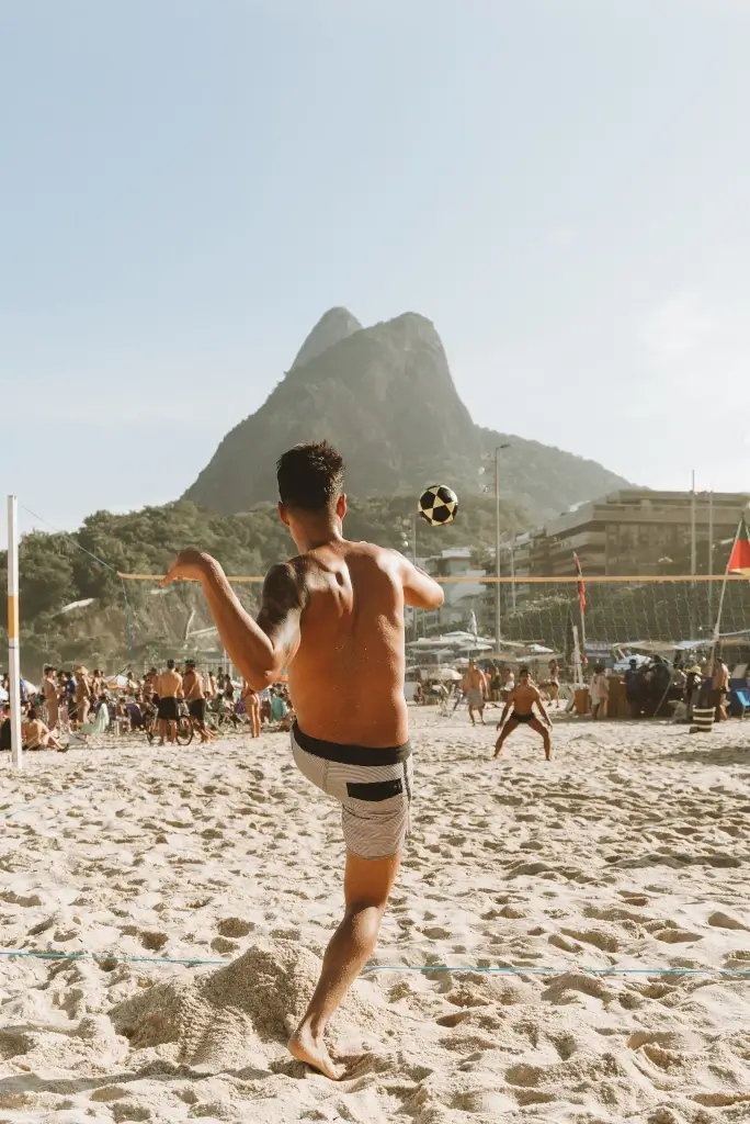Men playing football on Rio de Janeiro beach in Brazil. 